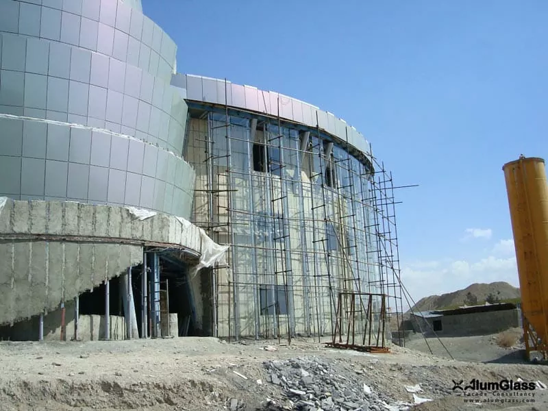 اجرای یک پوسته نمای شیشه‌ای اسپایدری در نمای خارجی ساختمان باغ هنر جهت تکمیل concept نما- آلومینیوم شیشه تهران